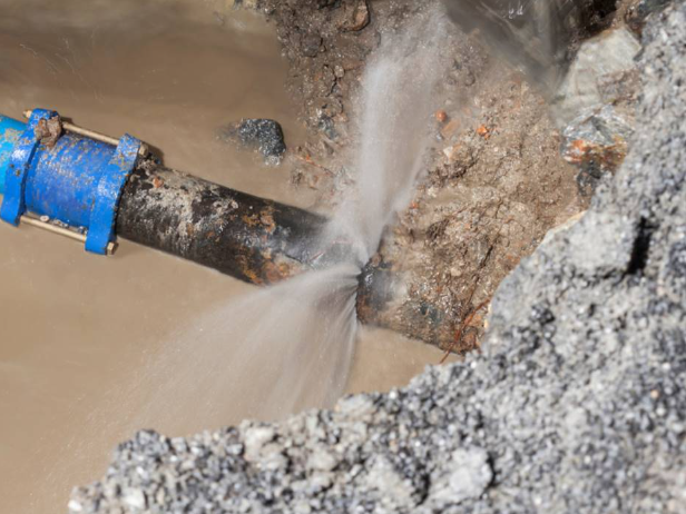Damaged main water line leaking, showing signs of water line repair needed.