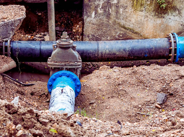 Exposed water line and valve in trench illustrating broken water line repair costs.